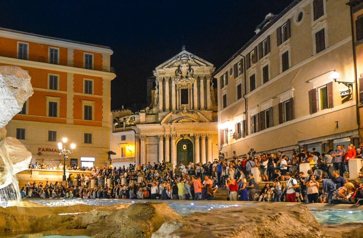Busy nightlife scene at the Trevi fountain in Rome, Italy 